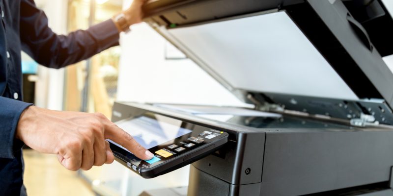 Bussiness man Hand press button on panel of printer, printer scanner laser office copy machine supplies start concept.